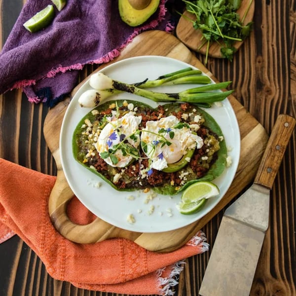 Chula Artisan Eatery's green enchiladas with chorizo, avocado, poached eggs, and grilled scallions.
