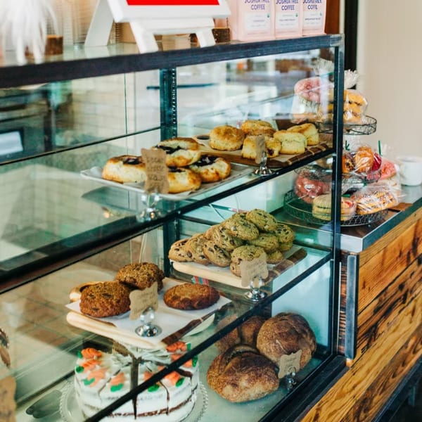 A glass display case filled with Chula Artisan Eatery's pastries, cookies, cakes, and bread.